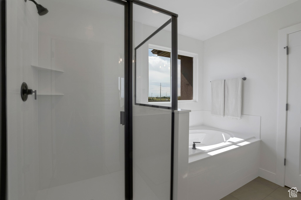 Full bathroom featuring a stall shower, a garden tub, and tile patterned flooring