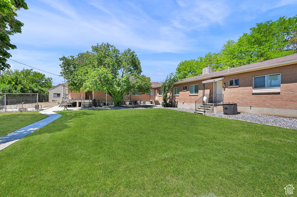 View of yard featuring central AC unit, a patio area, and entry steps