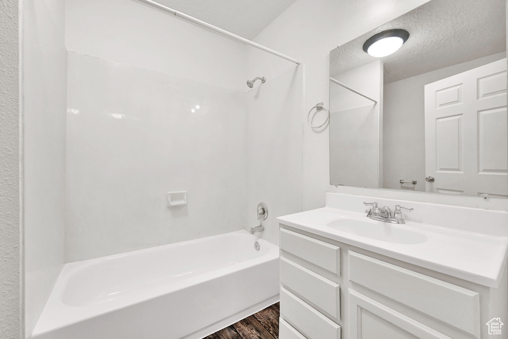 Full bathroom with tub / shower combination, wood finished floors, and vanity