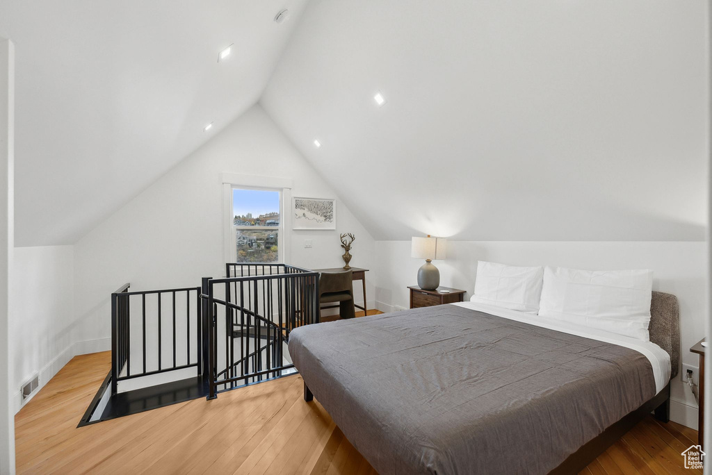 Bedroom with vaulted ceiling and wood finished floors