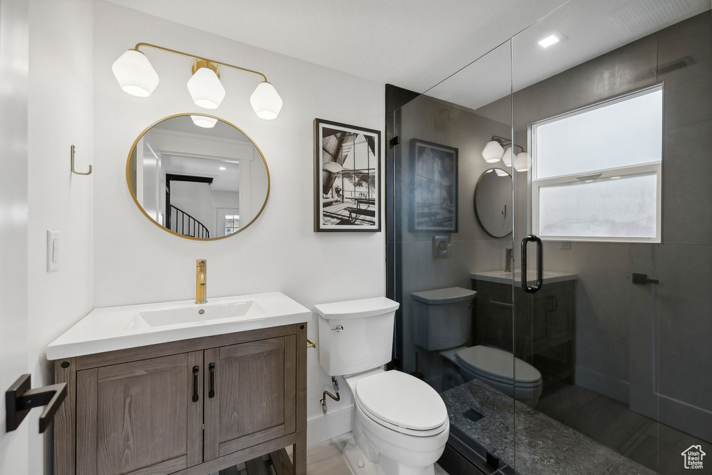 Bathroom with toilet, vanity, a stall shower, baseboards, and tile patterned floors