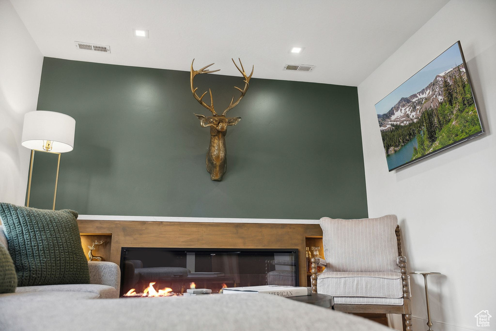 Sitting room with a glass covered fireplace and baseboards