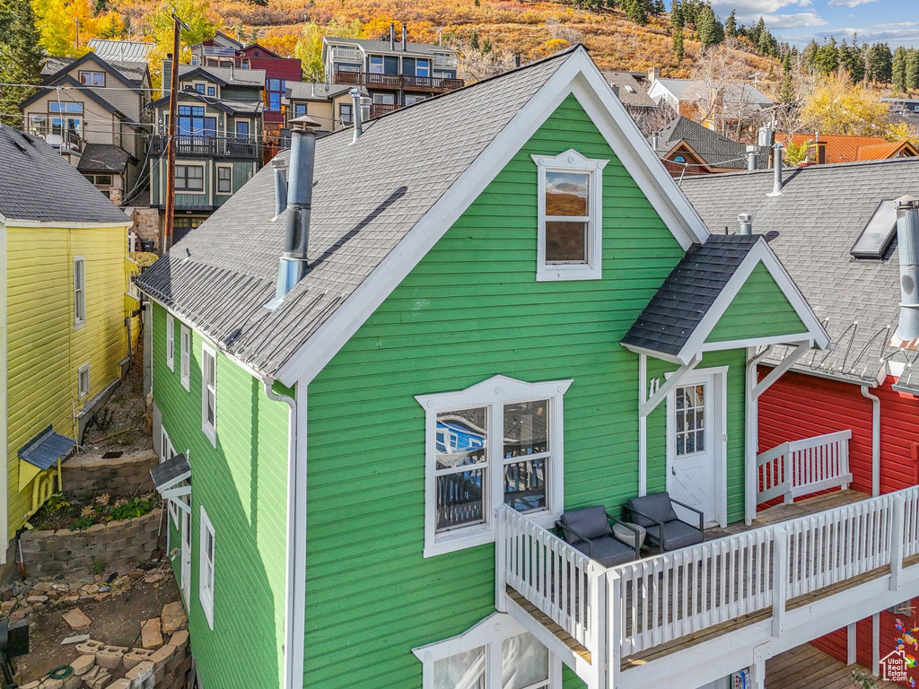 Rear view of property with a shingled roof and a residential view