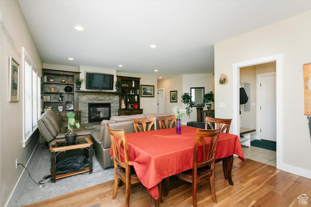 Dining space featuring a fireplace, wood finished floors, recessed lighting, and baseboards