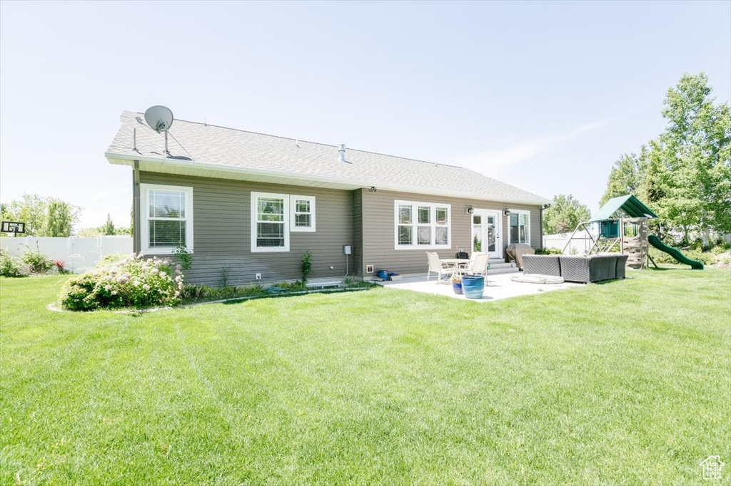 Back of property featuring a patio, a playground, an outdoor hangout area, and french doors