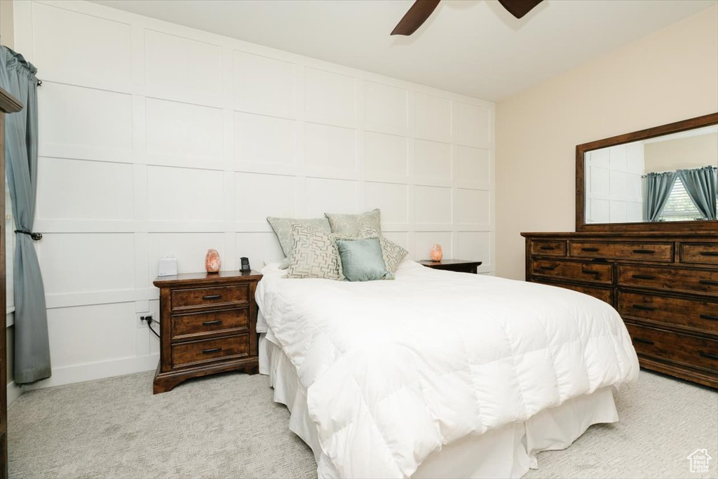 Bedroom with light colored carpet and a ceiling fan