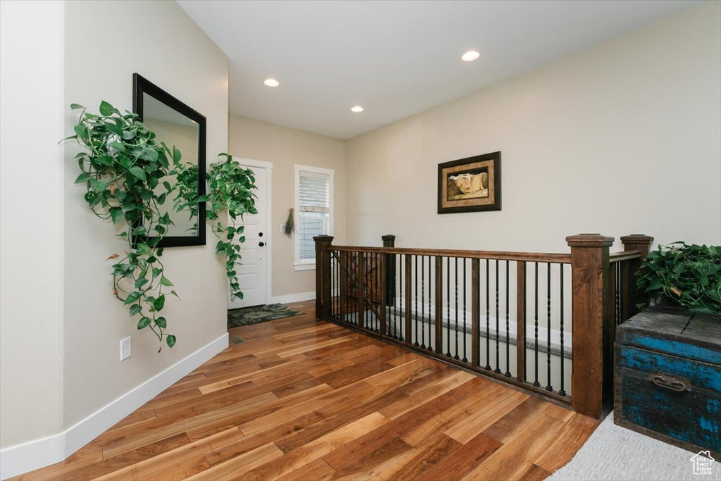 Hall featuring wood finished floors, recessed lighting, and baseboards