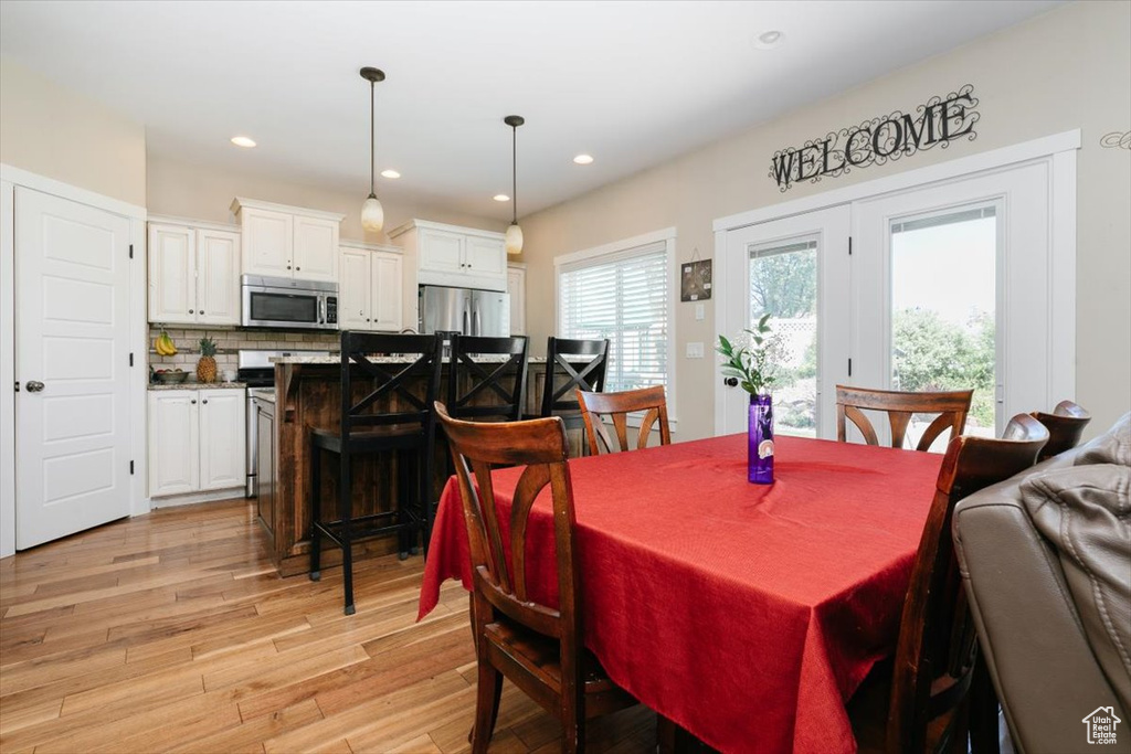 Dining area with light wood-style flooring and recessed lighting