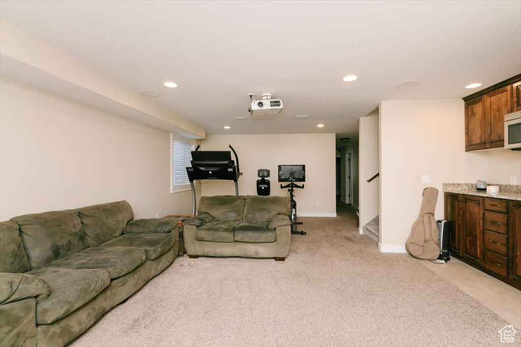 Living room with light carpet, recessed lighting, stairs, and baseboards