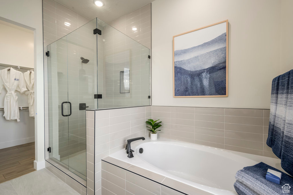 Full bath with a garden tub, a shower stall, recessed lighting, and baseboards