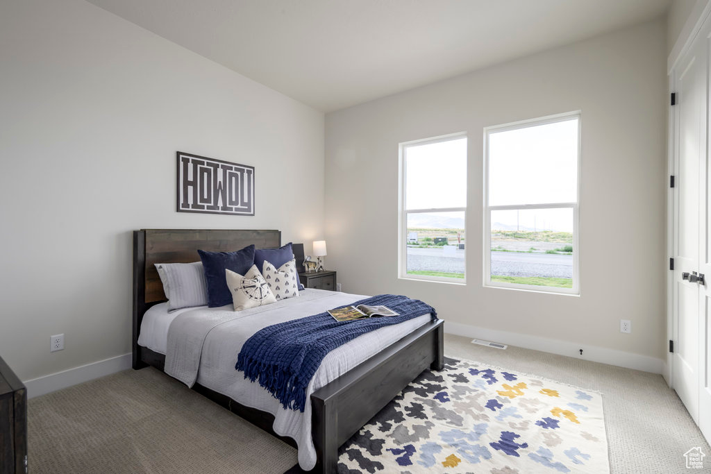 Bedroom with light carpet and baseboards