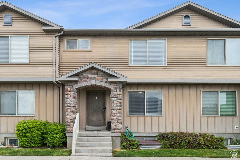 Townhome / multi-family property featuring stone siding