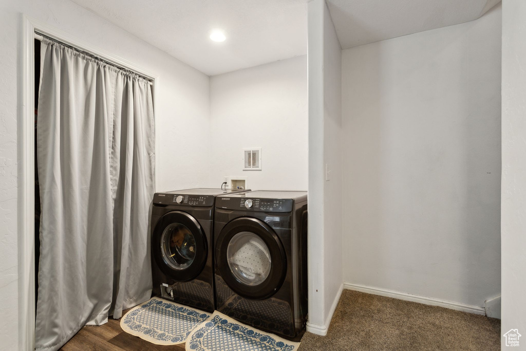 Laundry area featuring independent washer and dryer, baseboards, and carpet floors