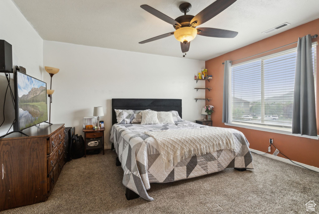 Carpeted bedroom with baseboards and ceiling fan