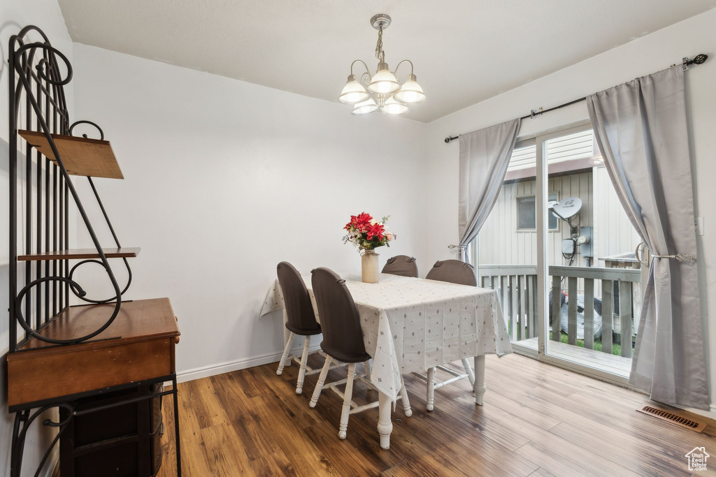 Dining room featuring a chandelier, wood finished floors, and baseboards
