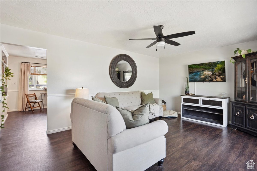Living room with ceiling fan, dark wood-style floors, and baseboards