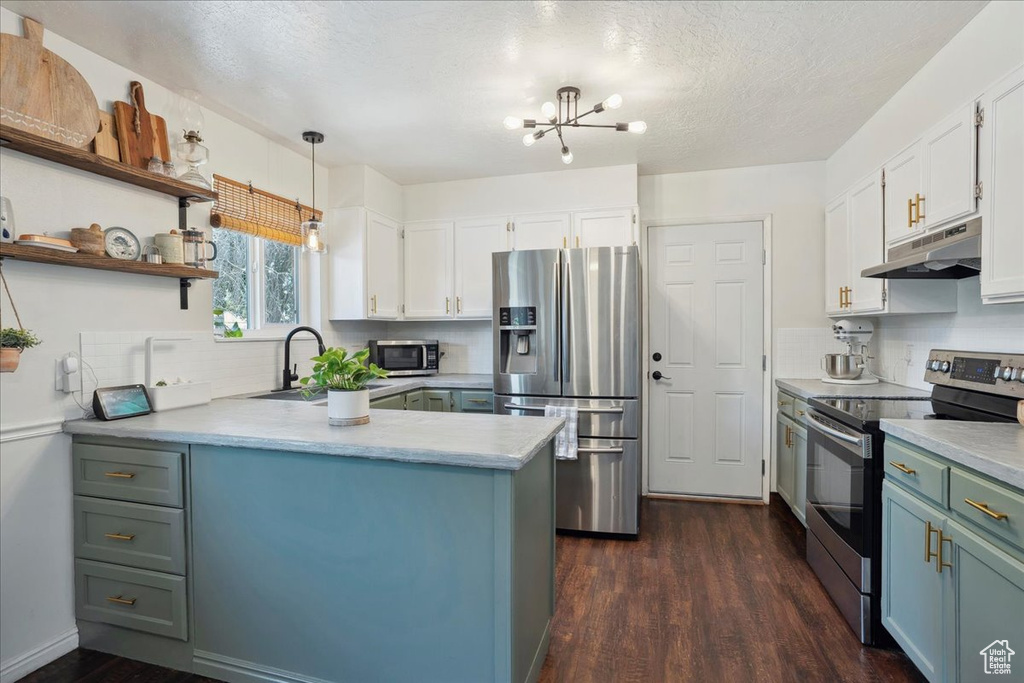 Kitchen with stainless steel appliances, under cabinet range hood, a sink, dark wood-style flooring, and backsplash