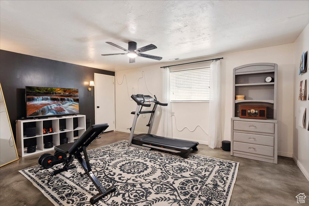 Workout area featuring a ceiling fan and baseboards