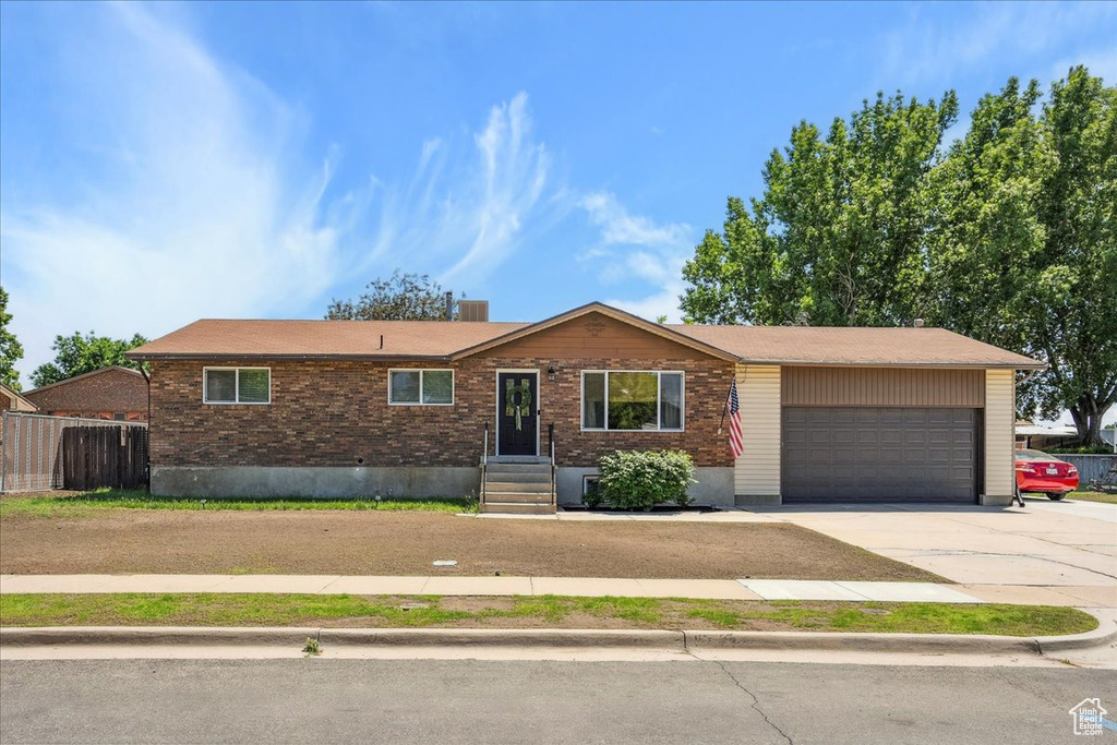Ranch-style home with concrete driveway, a garage, and brick siding