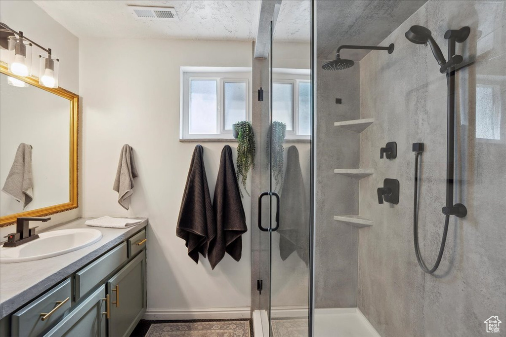 Full bathroom featuring vanity, a shower stall, and baseboards
