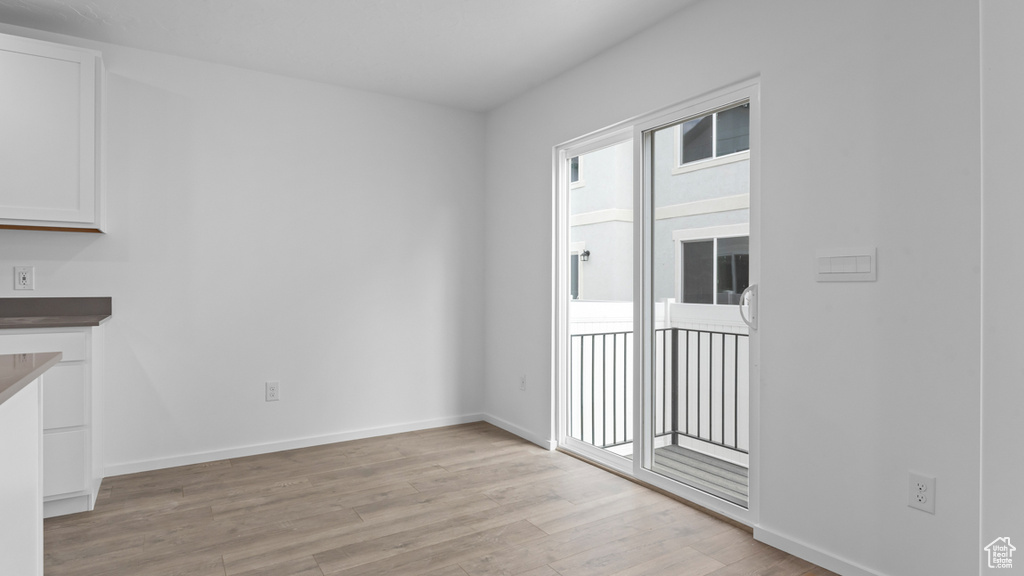 Unfurnished dining area featuring light wood-style floors and baseboards