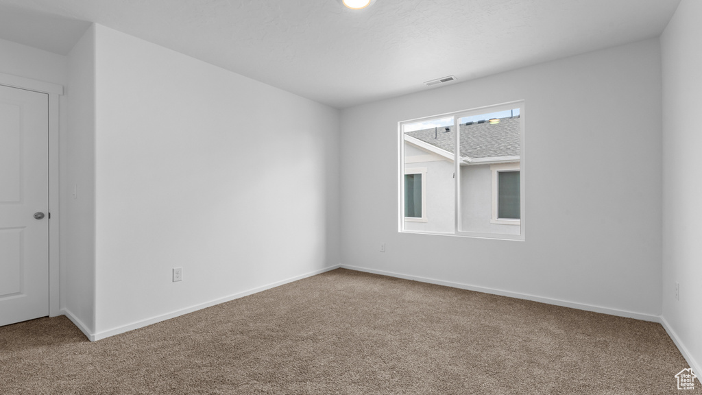 Empty room with carpet and baseboards
