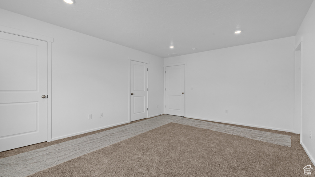Carpeted empty room with recessed lighting and baseboards