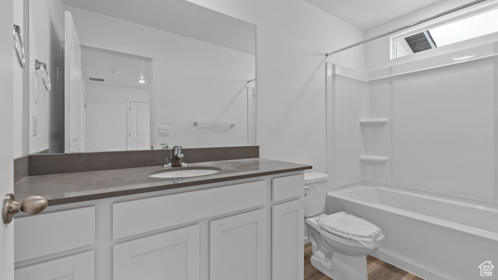 Full bath featuring toilet, wood finished floors, vanity, and bathtub / shower combination