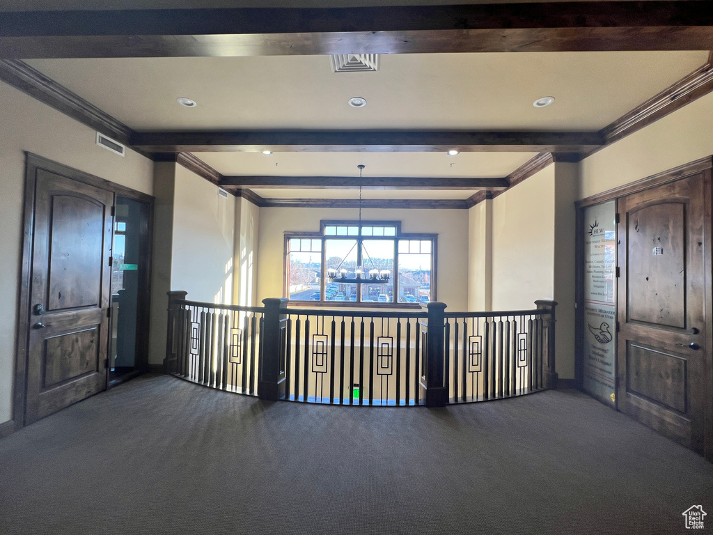Hallway with carpet floors, beamed ceiling, crown molding, a chandelier, and recessed lighting