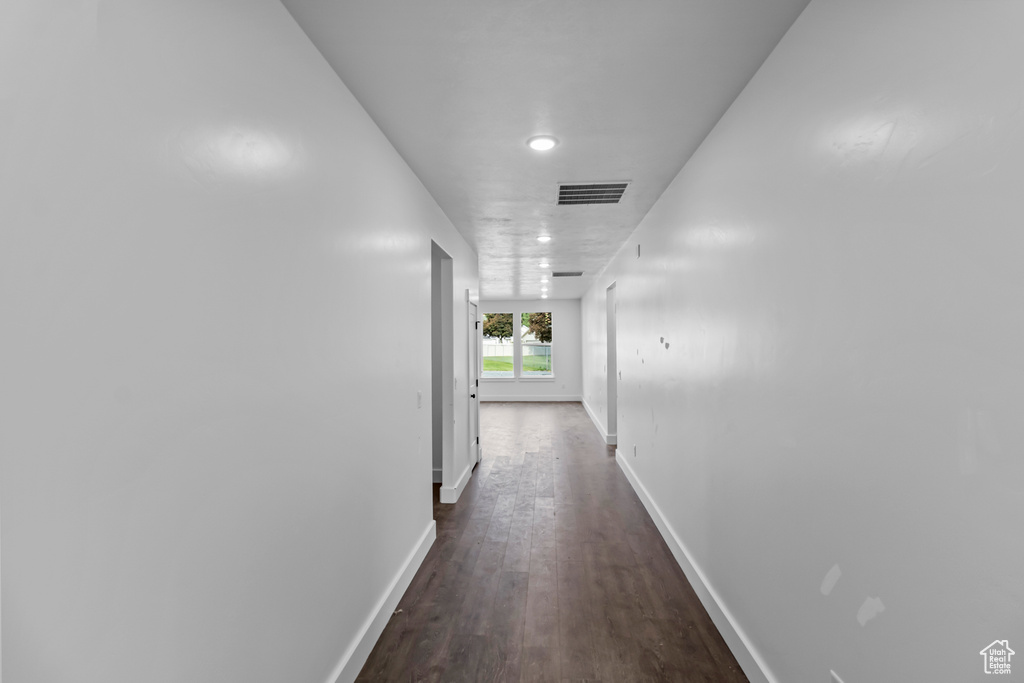 Hall with baseboards, dark wood-style flooring, and recessed lighting