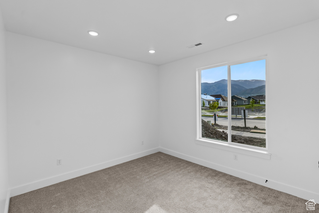 Spare room with carpet, a mountain view, recessed lighting, and baseboards