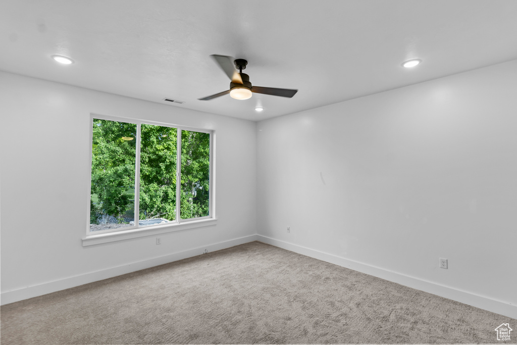 Carpeted spare room with ceiling fan, baseboards, and recessed lighting