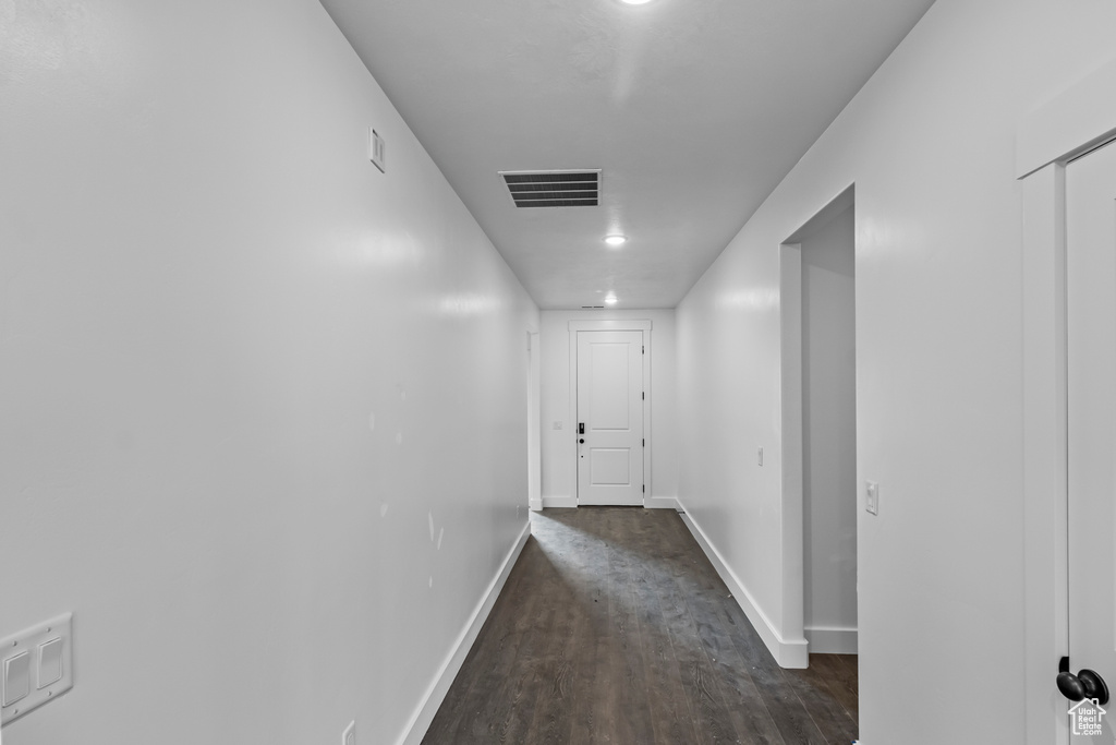 Hallway featuring wood finished floors and baseboards