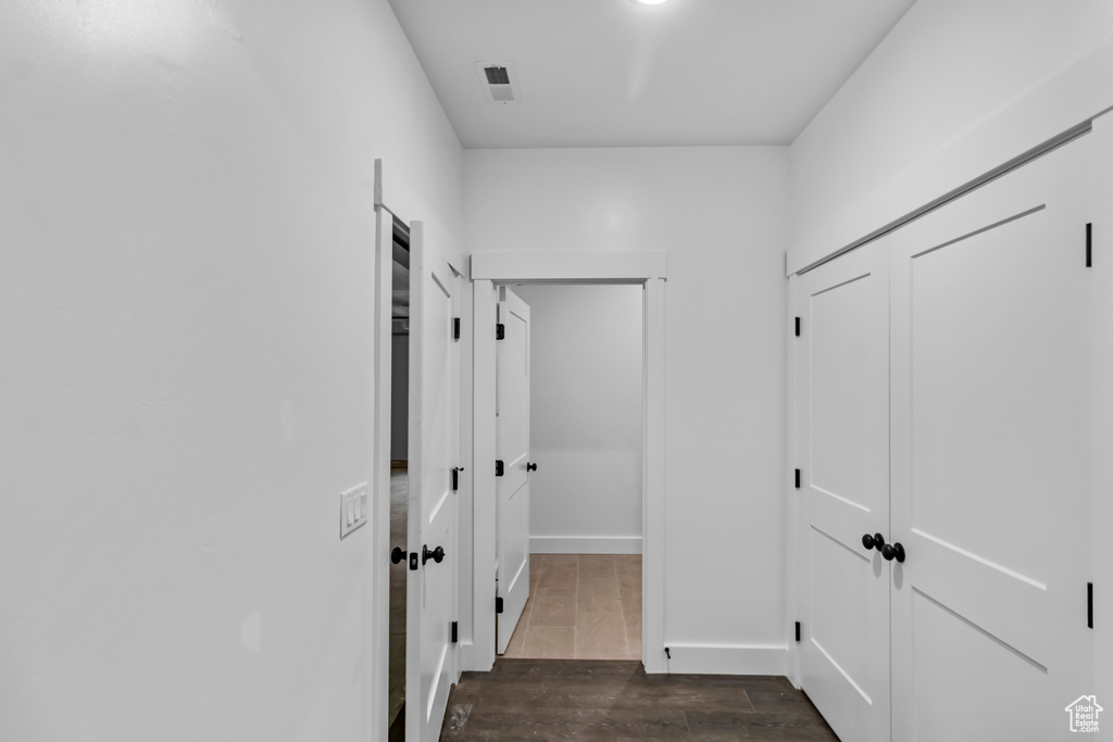 Corridor featuring dark wood-style flooring and baseboards