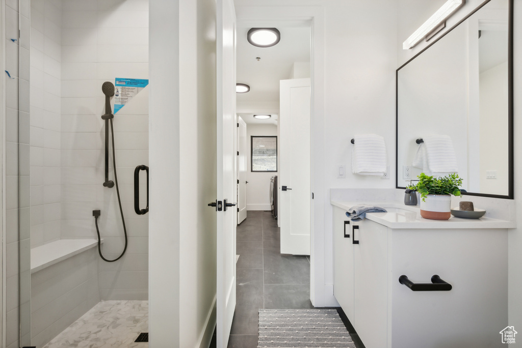 Full bathroom featuring a shower stall, vanity, tile patterned flooring, and baseboards