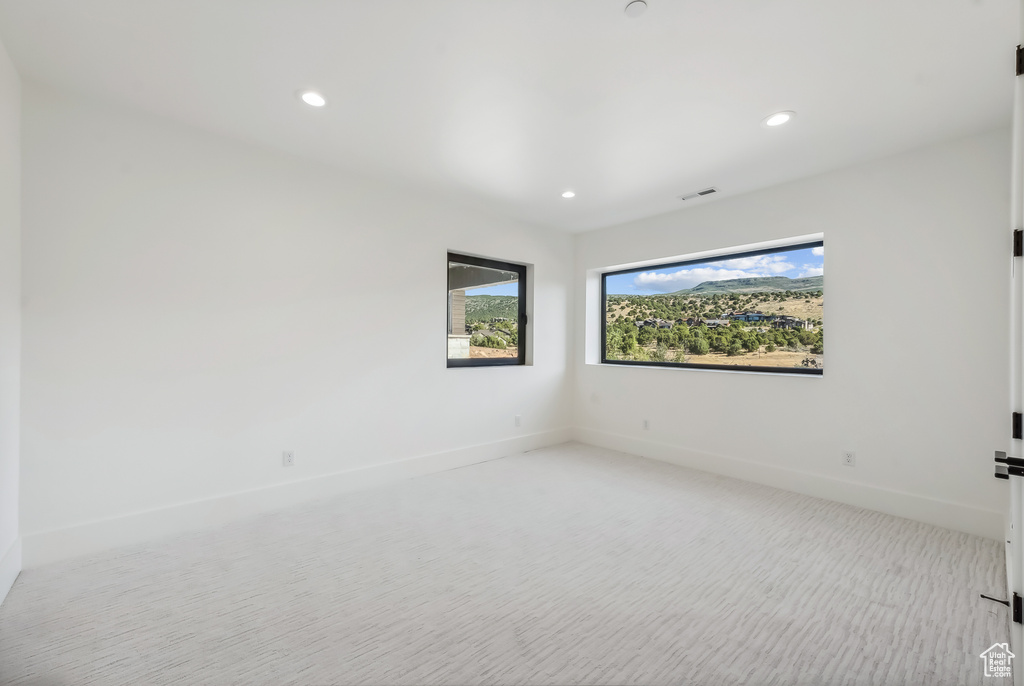 Spare room with light carpet, recessed lighting, and baseboards