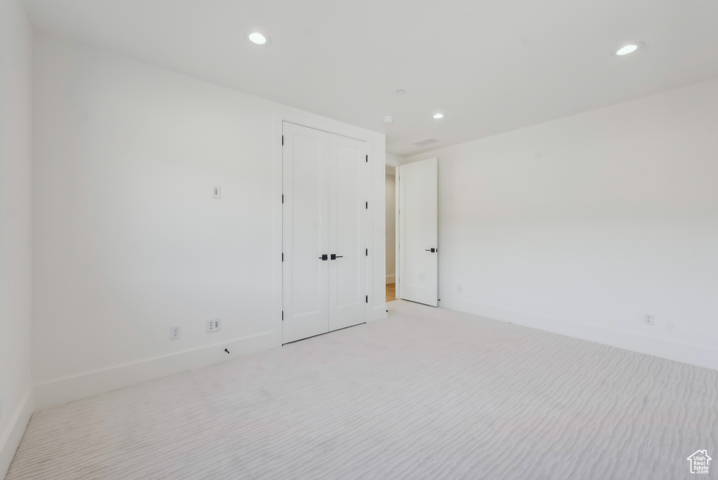 Empty room featuring light colored carpet, recessed lighting, and baseboards