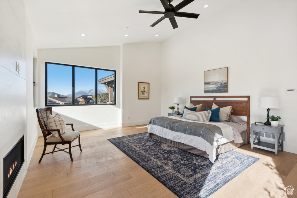 Bedroom with vaulted ceiling, baseboards, light wood finished floors, recessed lighting, and ceiling fan