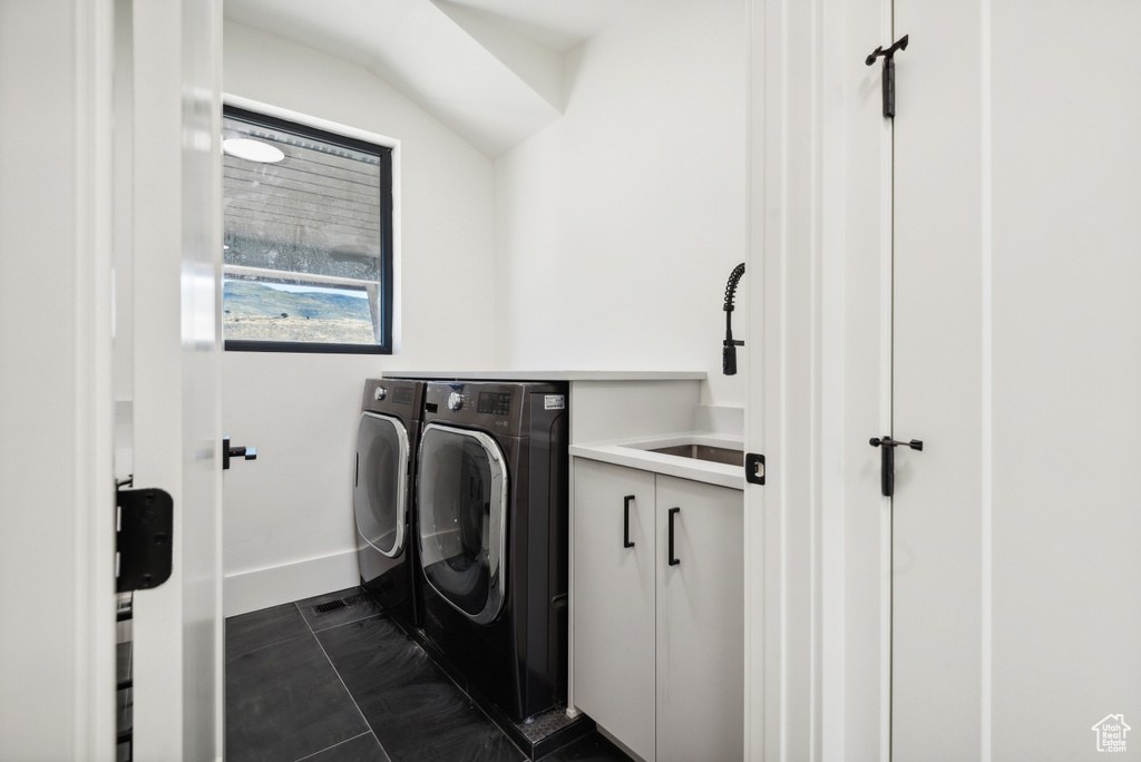 Washroom with independent washer and dryer, a sink, and baseboards