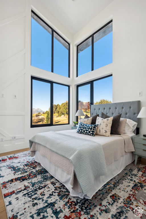Bedroom featuring a towering ceiling and wood finished floors