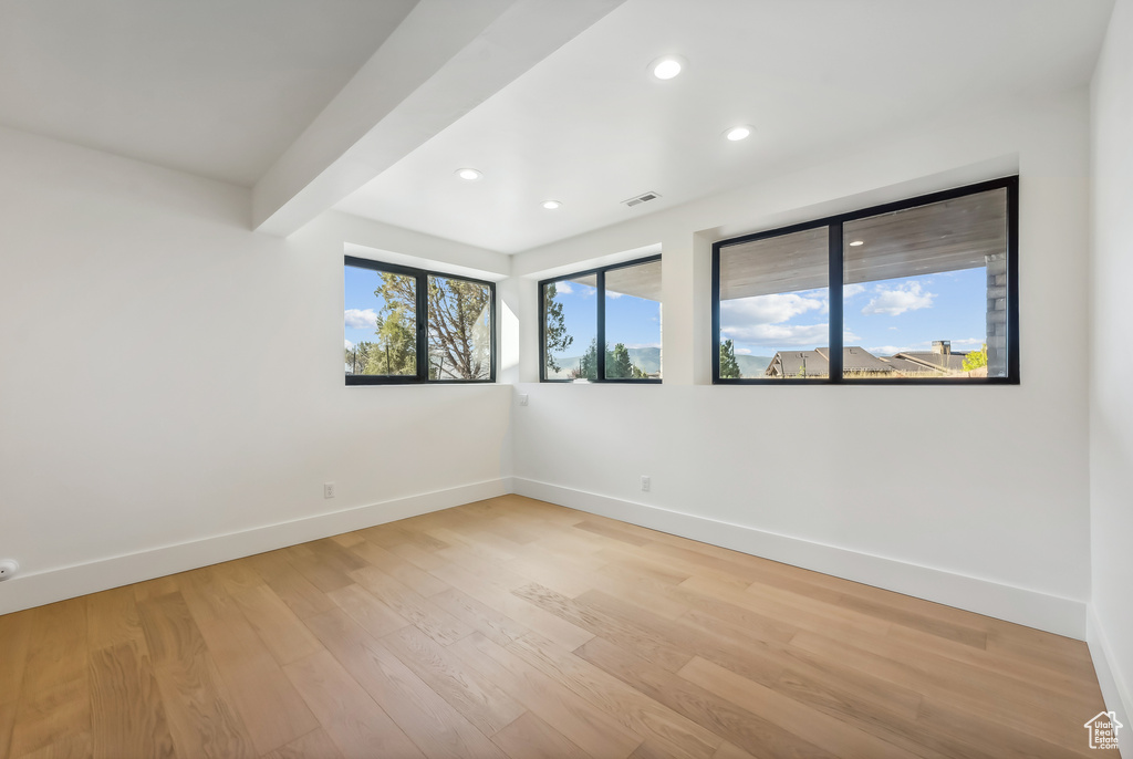 Spare room featuring baseboards, recessed lighting, and light wood-style flooring