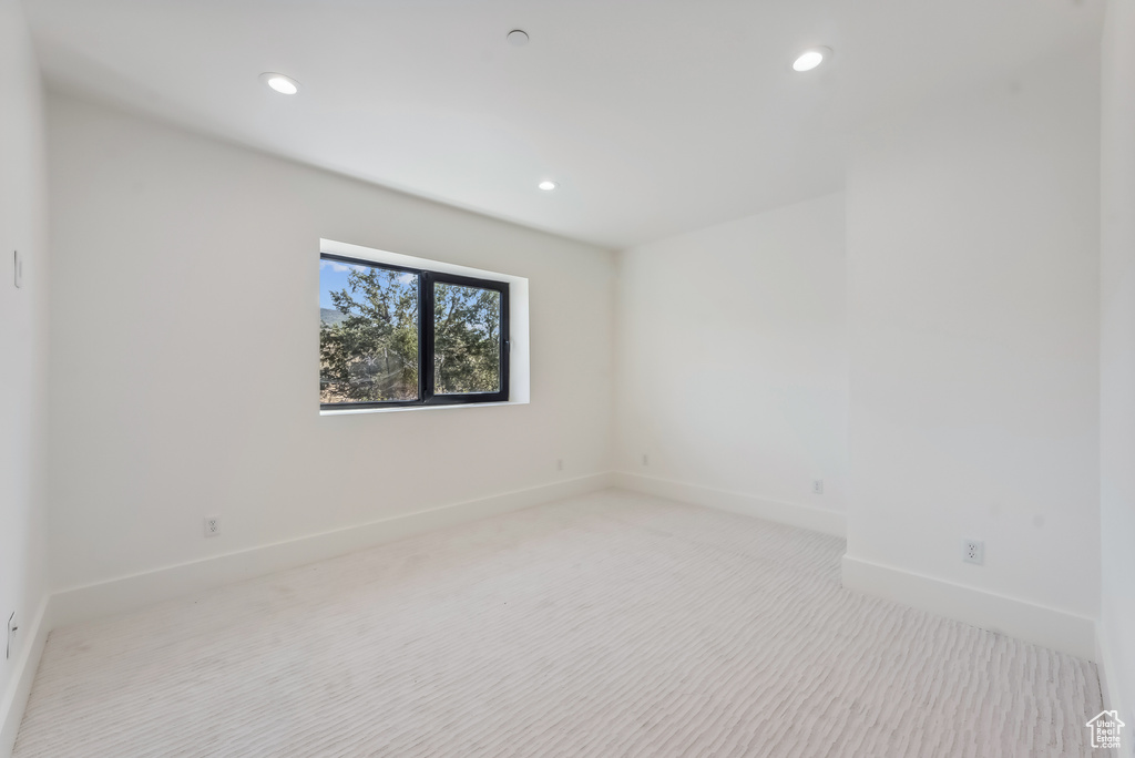 Spare room with light carpet, baseboards, and recessed lighting