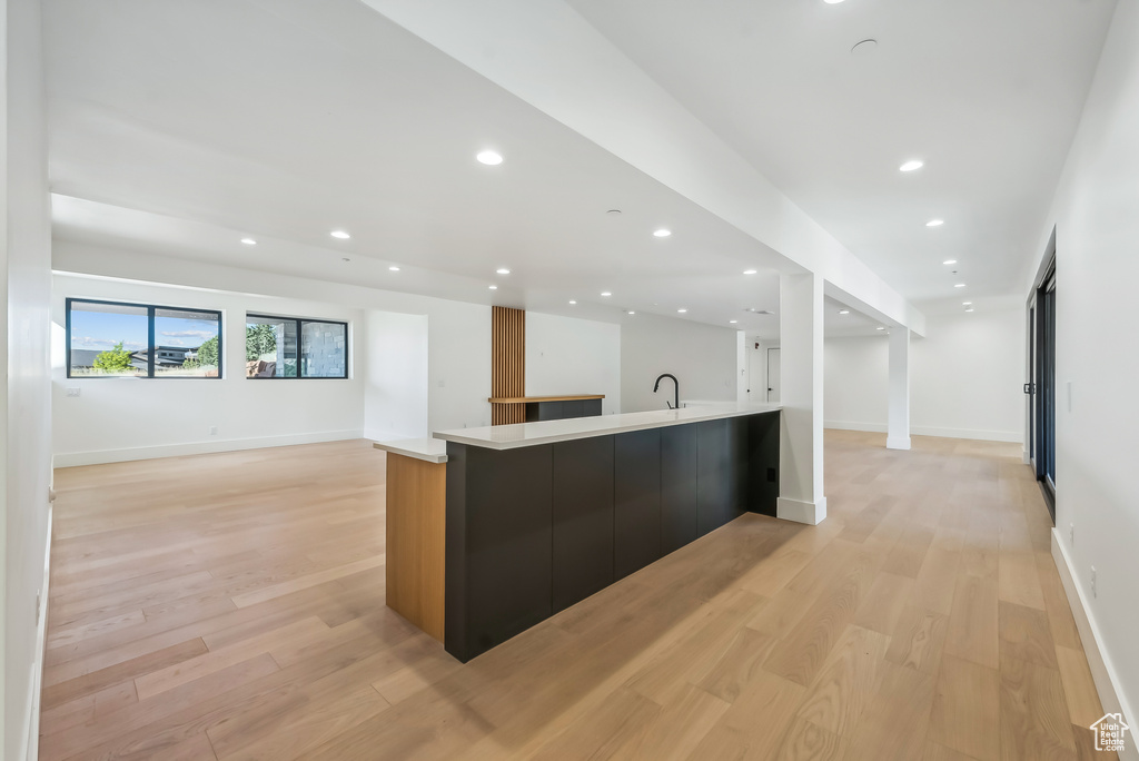 Kitchen with open floor plan, modern cabinets, a sink, light countertops, and recessed lighting