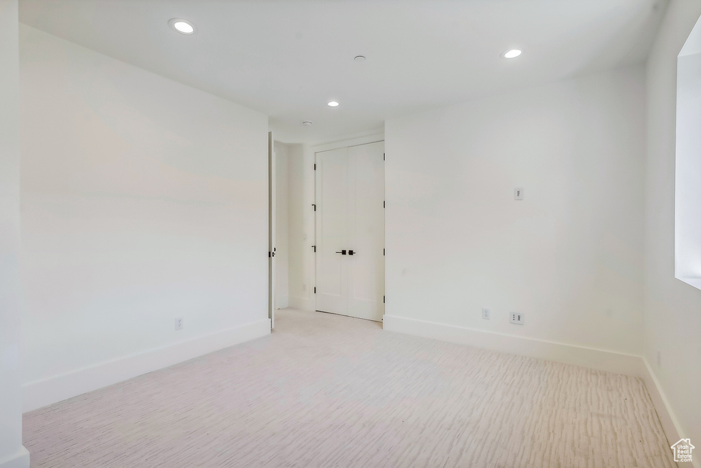 Unfurnished room featuring baseboards, recessed lighting, and light carpet