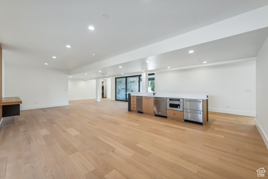 Kitchen featuring appliances with stainless steel finishes, light wood-type flooring, recessed lighting, baseboards, and light countertops
