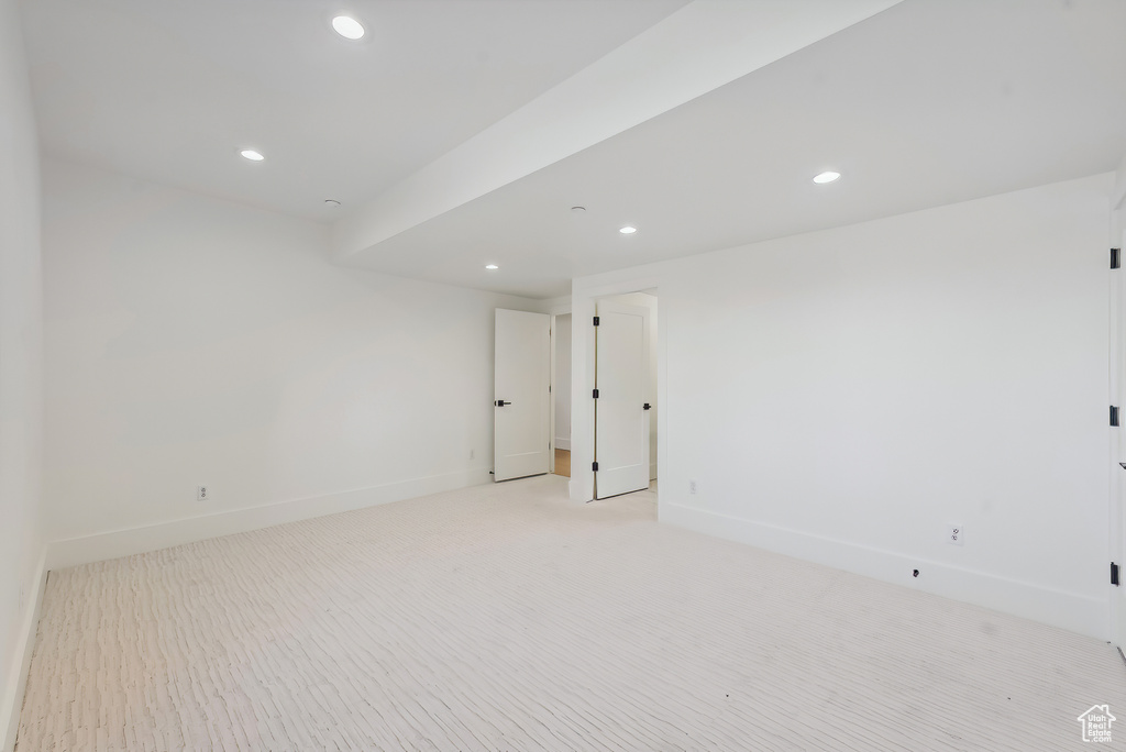 Empty room featuring recessed lighting, baseboards, and light carpet