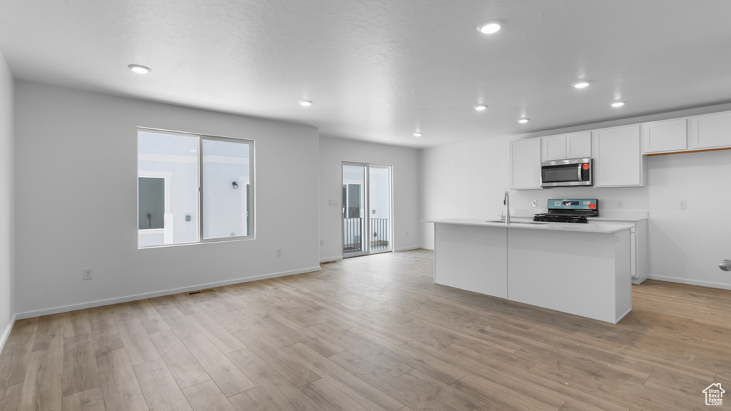 Kitchen featuring stainless steel appliances, white cabinets, recessed lighting, light countertops, and baseboards