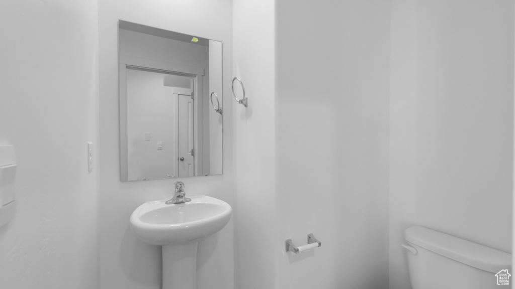 Half bath featuring toilet and a sink