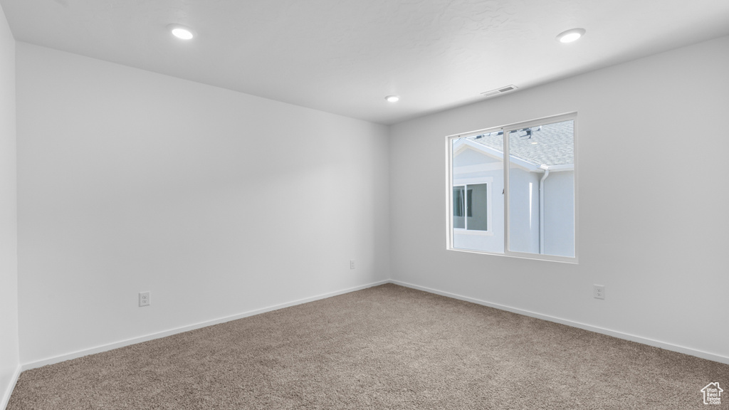 Spare room featuring carpet, baseboards, and recessed lighting
