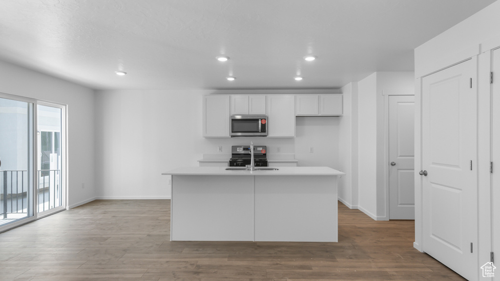 Kitchen with stainless steel appliances, plenty of natural light, baseboards, and recessed lighting